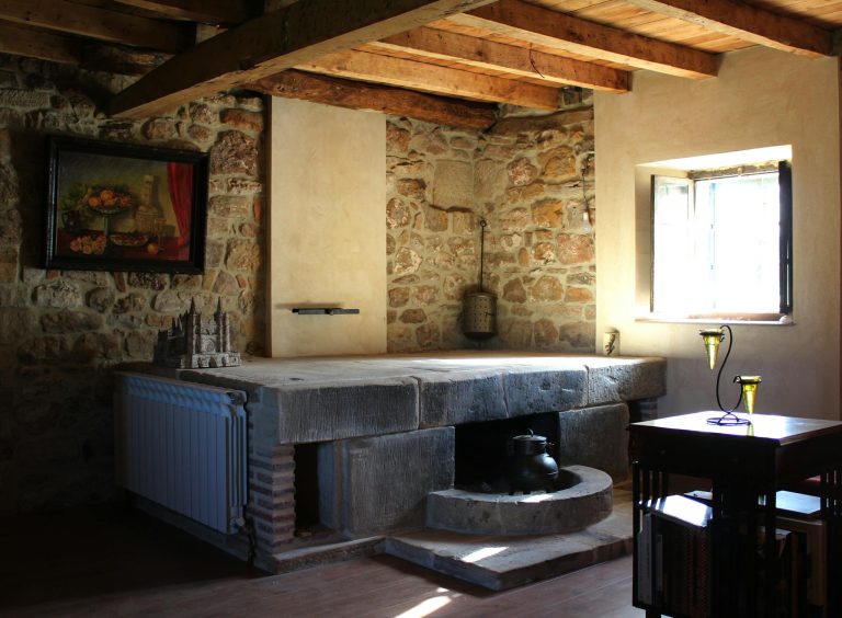 A charming rustic interior featuring stone walls, wooden beams, and vintage decor elements.