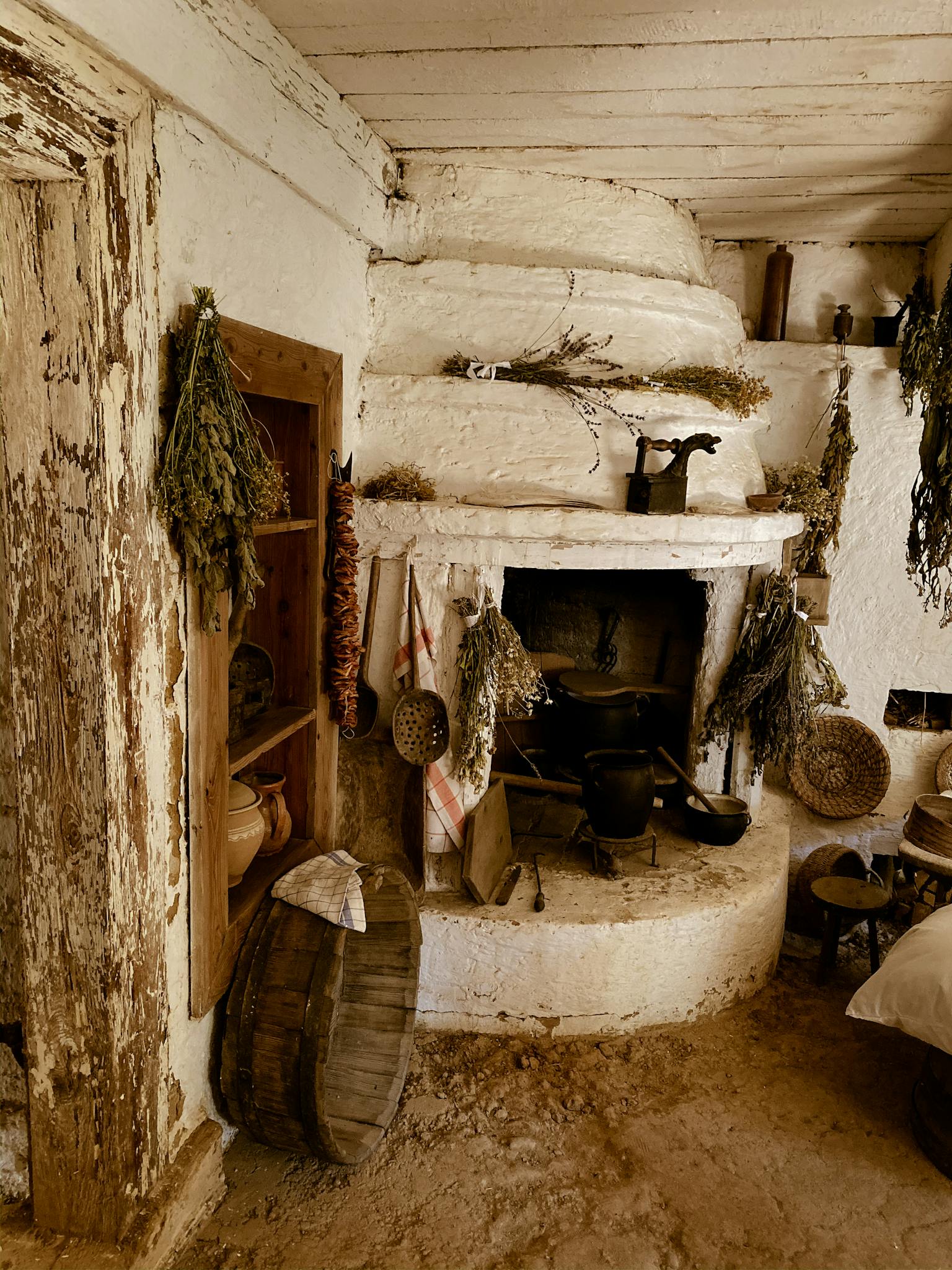 Charming rustic interior of a traditional Polish farmhouse with vintage fireplace and dried herbs.